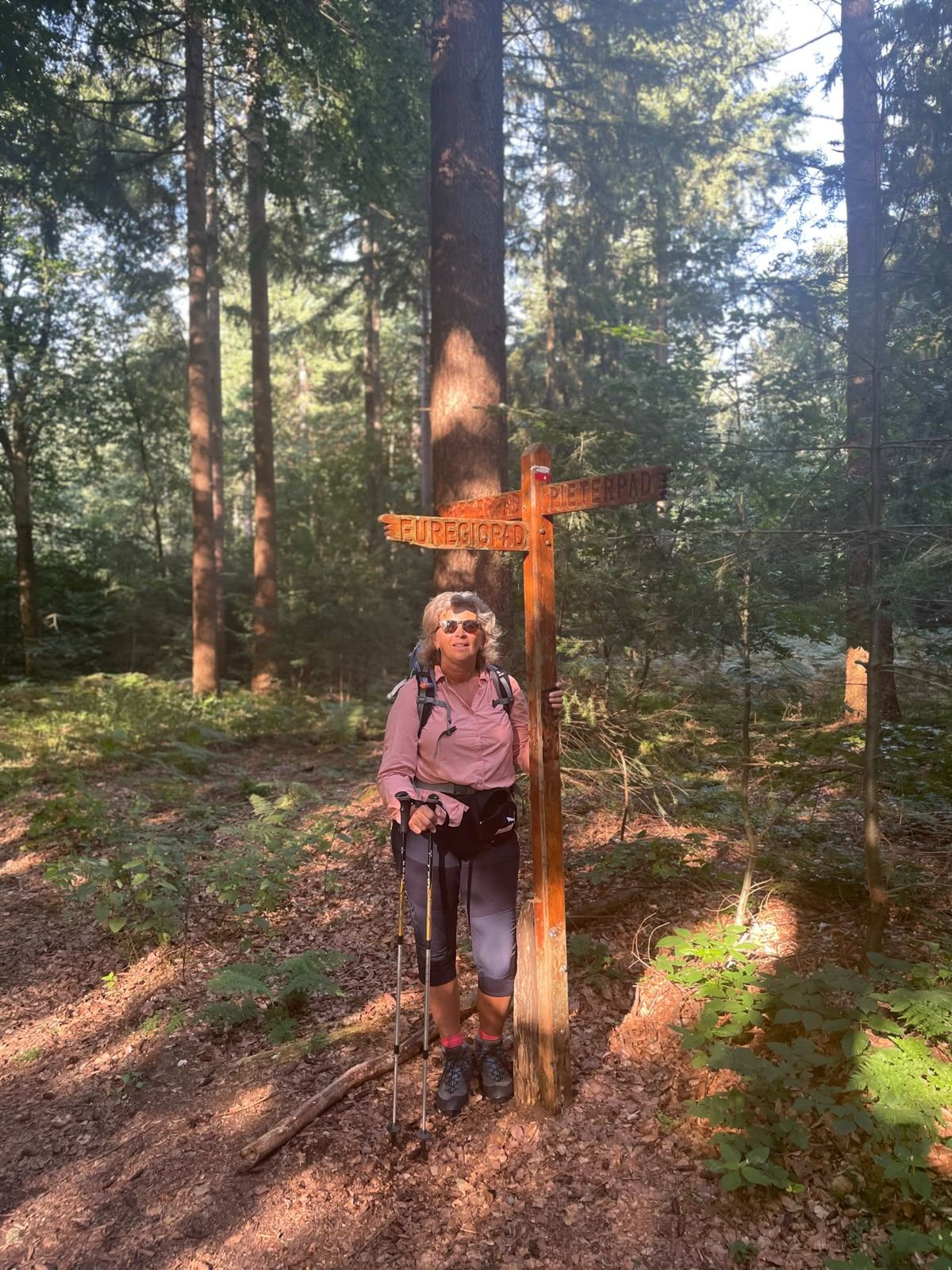 Anne-Marie bij een Pieterpad-wegwijzer in het bos